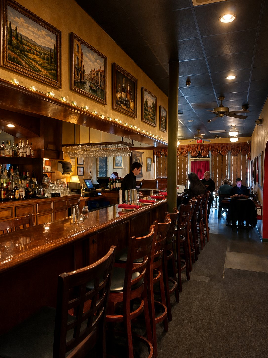 The bar at SOLO — warm wood, framed Italian scenes, glassware